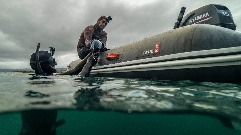 True Kit Discovery 330 Dark Grey being used as a diving platform in Fiordland, New Zealand