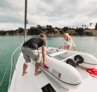 man and woman setting up sailboat